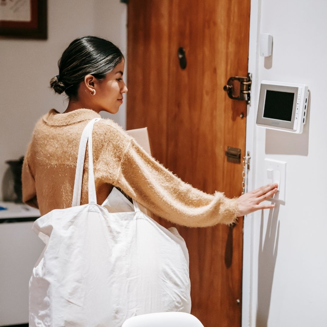 person adjusting the thermostat in their home