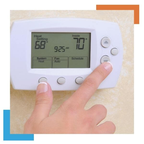 person adjusting their thermostat