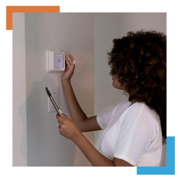 woman adjusting her thermostat